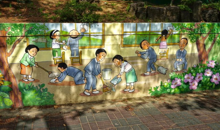 A mural showing Asian students helping to clean the classroom.