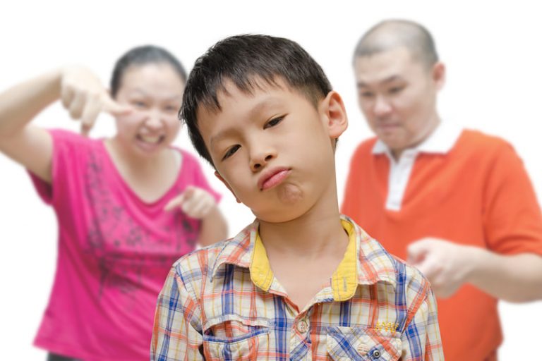 Asian parents scolding their young son.