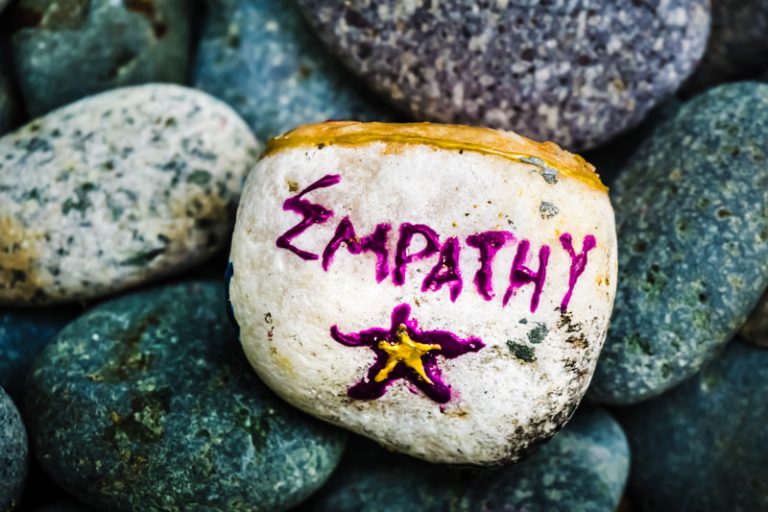 Colorful painted rock with the word 'Empathy' on it.