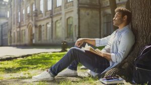 A man sitting hold a book and thinking.