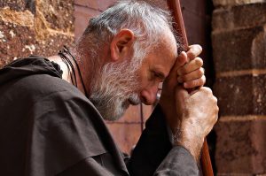 A monk leaning on his staff.