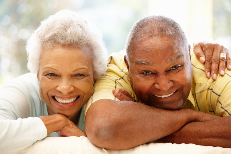 Older smiling African American couple at home.