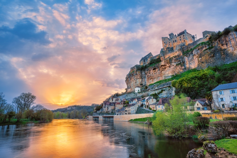 Beynac-et-Cazenac village with medieval Chateau Beynac during a dramatic sunset, Dordogne, South of France.