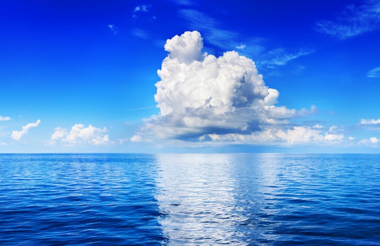 White cumulus clouds over the ocean.