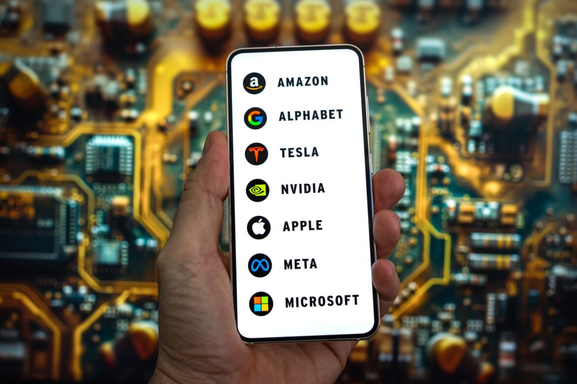 A hand holding a smartphone displaying logos of major tech companies.