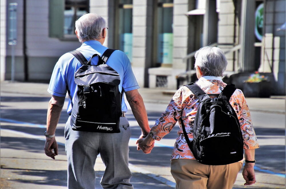 An older couple walking hand in hand.