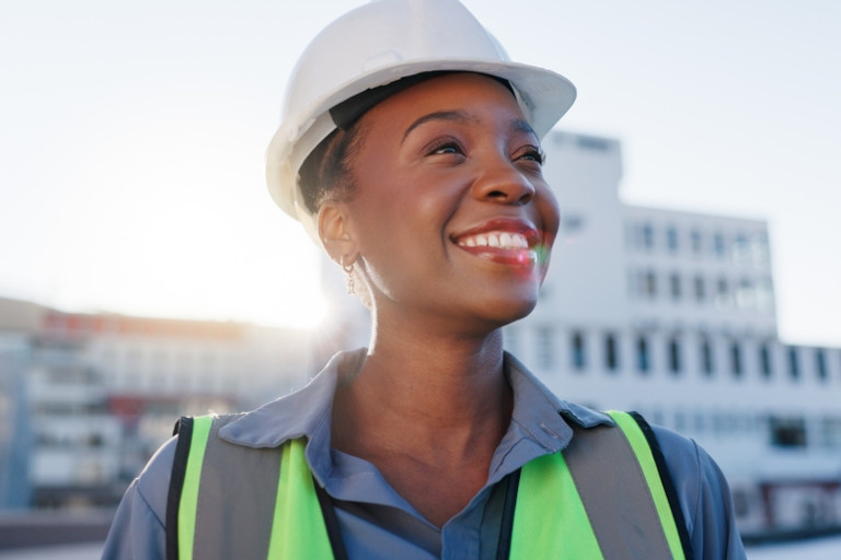 Smiling African American woman wearing a white hardhat.