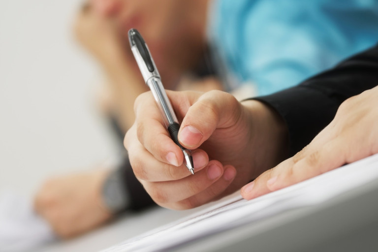 College students sitting in class writing notes.