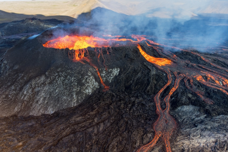 Eruption of Mauna Loa Volcano in Hawaii with smoke and a hazy sky.