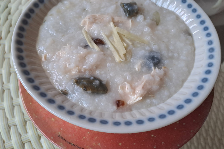 A bowl of chicken and ginger porridge served with a century egg.