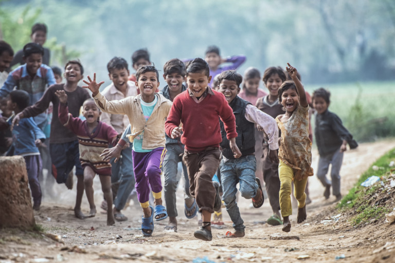 A group of boisterous Indian children running.