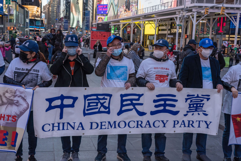 Chinese pro-democracy activists hold banners during a China Democracy Party demonstration at Times Square on March 13, 2021 in New York City.