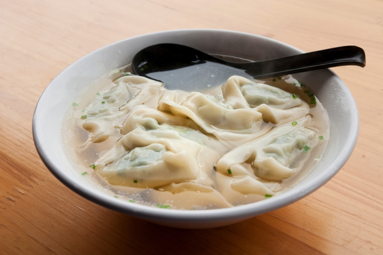 Bowl of Asian dumplings cooked in pork broth.