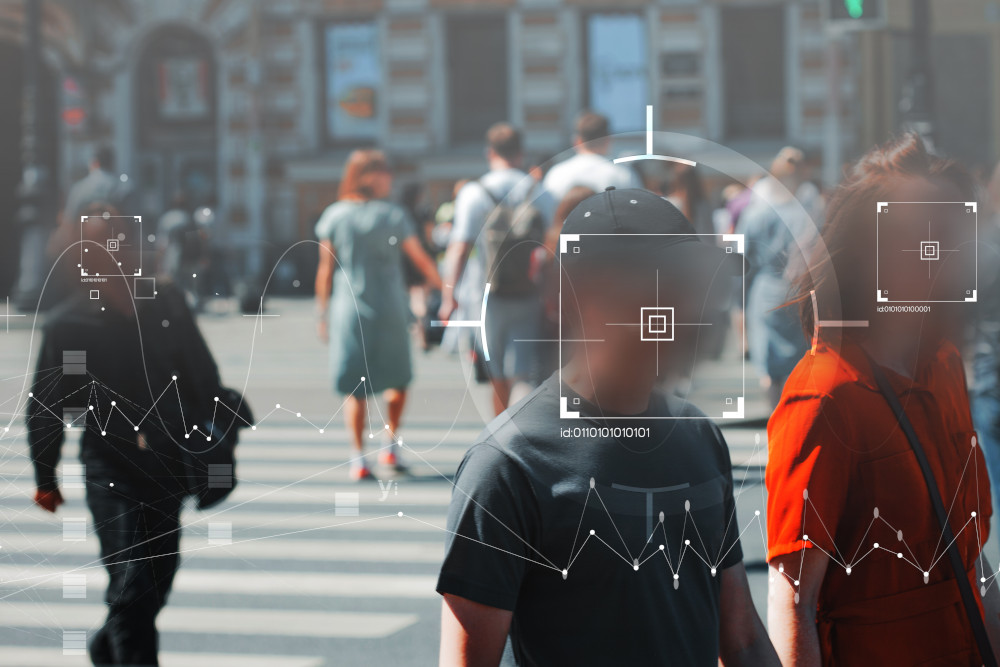 Graphical elements of facial recognition technology overlaid on a scene of people walking on a street.