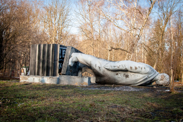 A monument to Lenin that is toppled over and being dismantled in a city park in Ukraine.