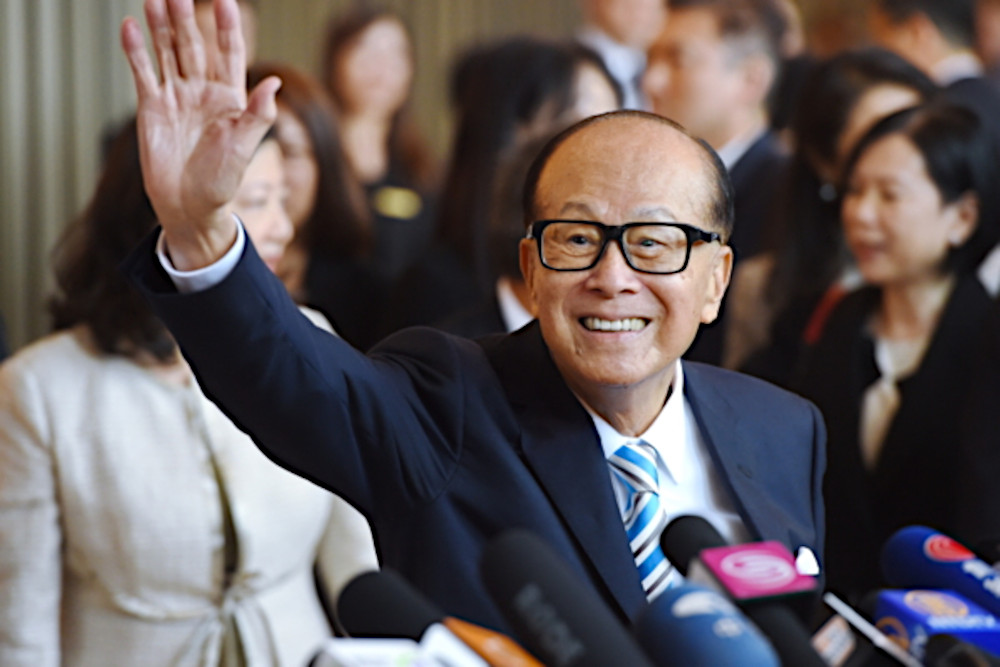 Hong Kong billionaire Li Ka-shing waving at the crowd during a press conference.