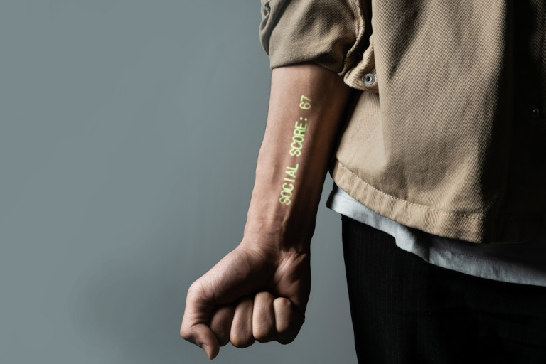Luminous brand on a person's arm reading 'social credit score = 67'.
