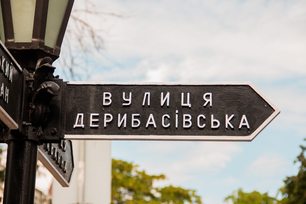 Stock photo of a Ukrainian street sign in Cyrillic with a sky background.