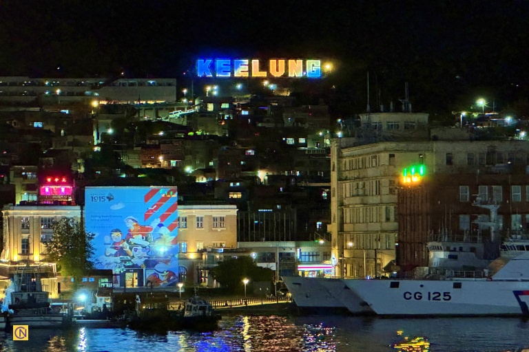 The iconic 'KEELUNG' sign glows above the bustling harbor after dark.