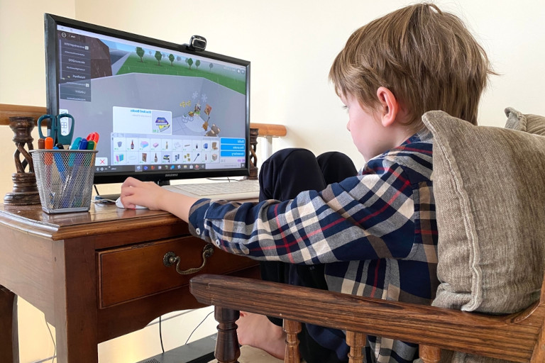 Child playing Roblox on a desktop computer.