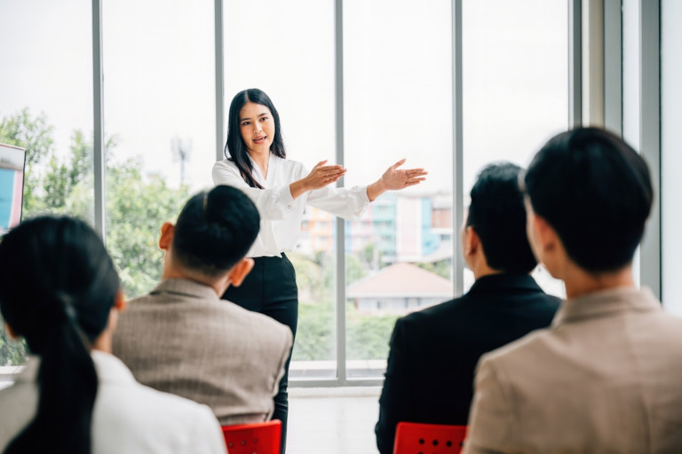 Young female giving a presentation at a business meeting.