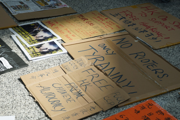 Protest signs in Hong Kong laying on the sidewalk.