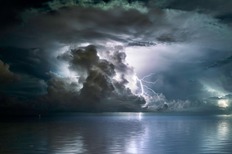 Ocean storm with lightning in the clouds.