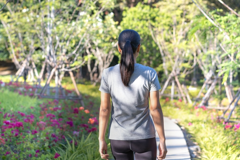 Asian woman taking a walk in the park in the morning.