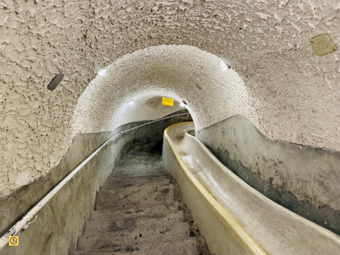 The West Secret Passage features a distinctive winding slide alongside a staircase, allowing for rapid evacuation during emergencies.