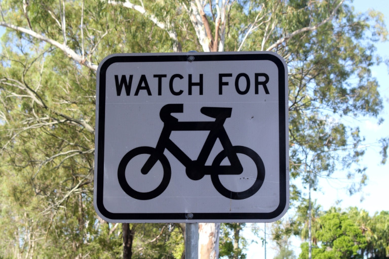 Watch For Bicycles sign in front of a eucalyptus tree in Australia.