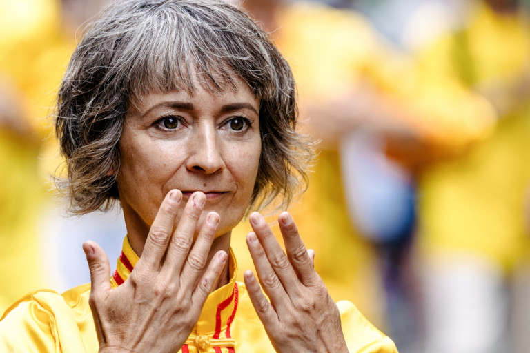 Woman demonstrating the exercises of the spiritual practice known as Falun Dafa.