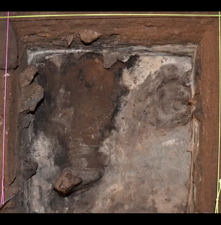 Bird’s eye view of the standing stone inside the cave (bottom left of photo), showing the white and grey ash from burnt grass all around it.