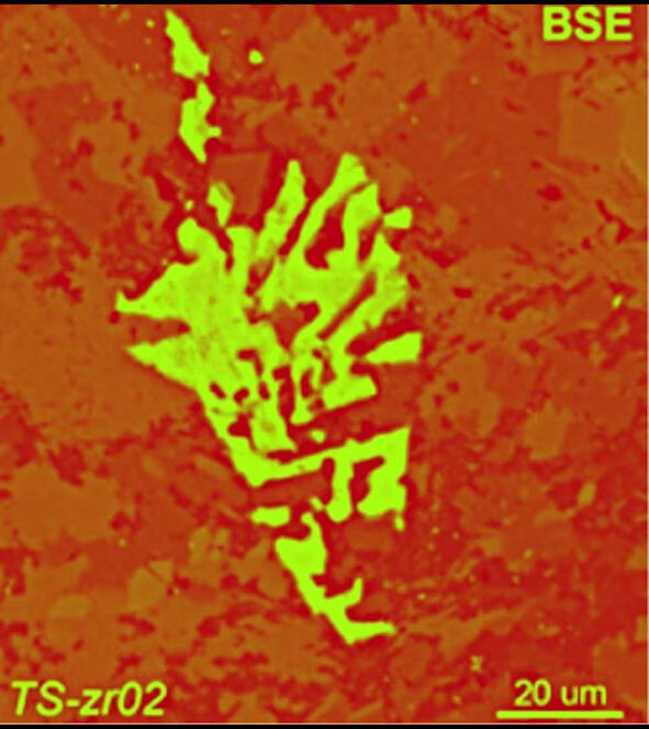 A false color image of a skeletal zircon grain (in green). The scale bar is 20 microns, about 1/3 the width of a human hair.