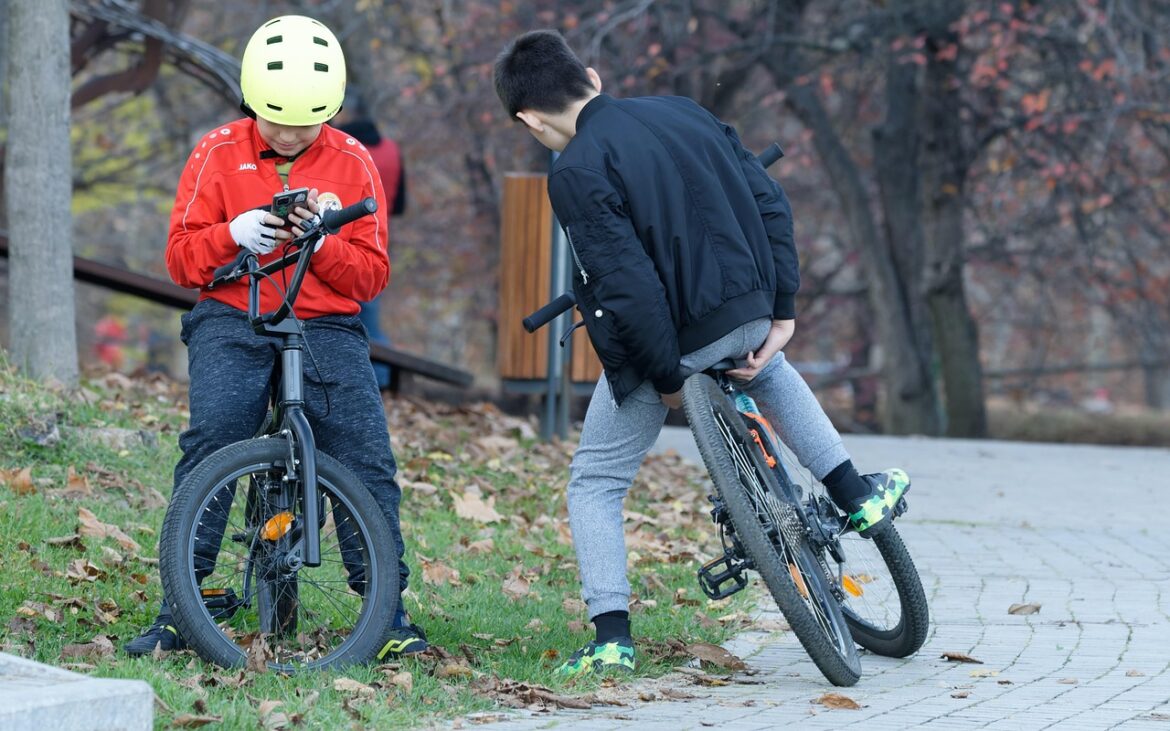 Two boys on bikes using social media.