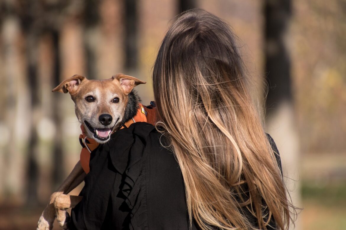 A woman carrying her dog.