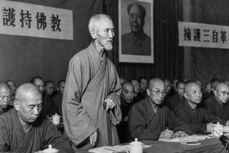 AI-generated image of an elderly Buddhist monk standing to defend Buddhist traditions during a meeting attended by monks and Communist officials in 1950s China.