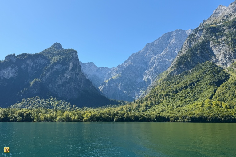 Steep cliffs surround much of the lake, while majestic Mount Watzmann rises dramatically nearby.