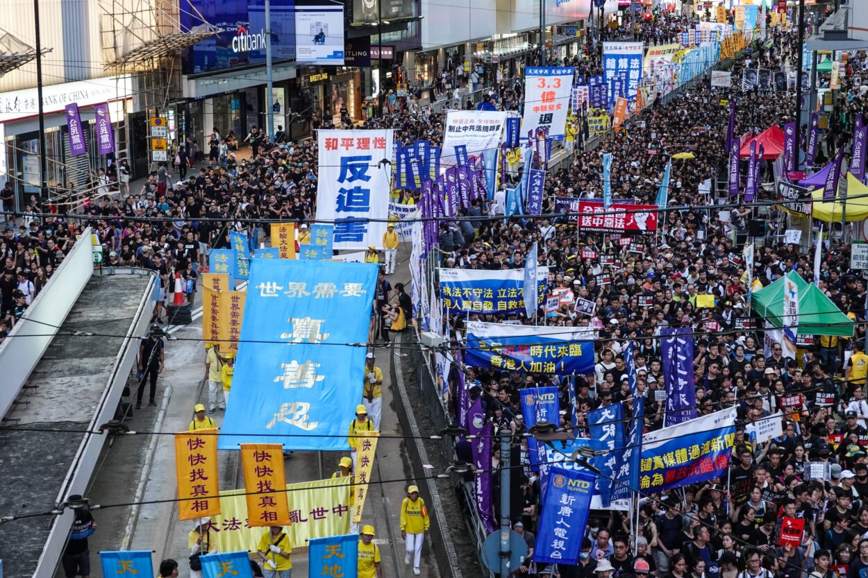 A march through Hong Kong during the 2019 protests. The banner reads 'The world needs Truthfulness, Compassion, Forbearance.' Photojournalist Adrian Yu won a Gold Award for the photograph.